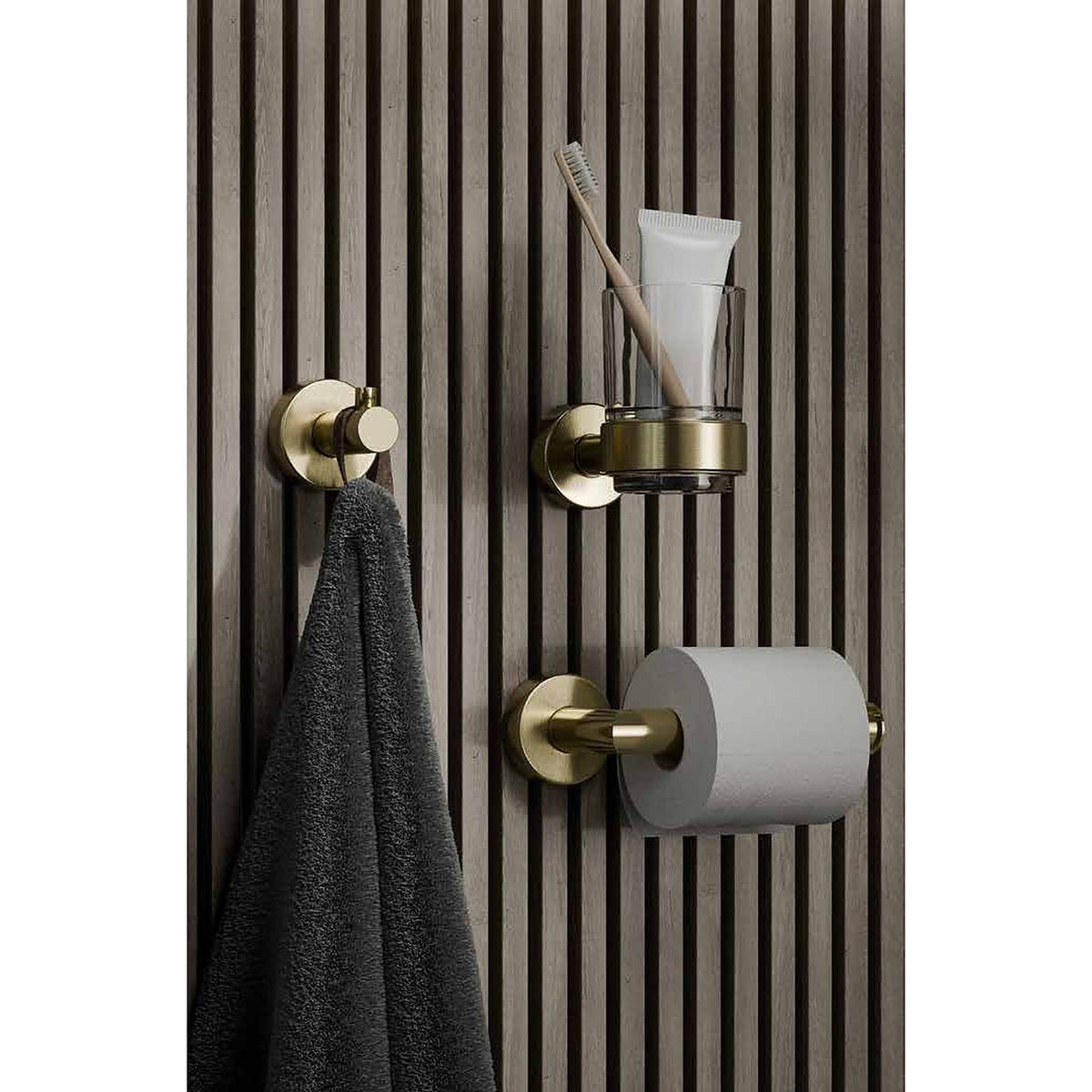 Artisa accessories in brushed brass on a slatted wall