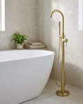 Aurea Brushed Brass Freestanding Bath Shower Mixer in a bright modern bathroom